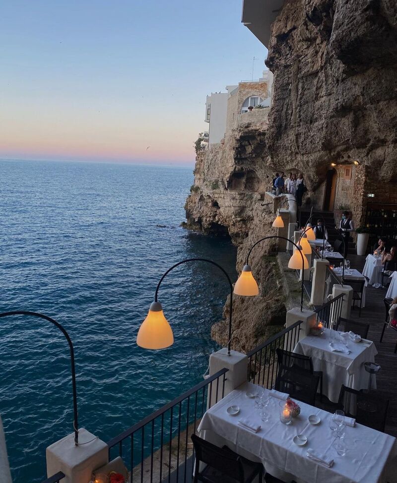 Terrazza esterna con vista sui Sassi illuminati al tramonto e tavoli in ferro battuto
